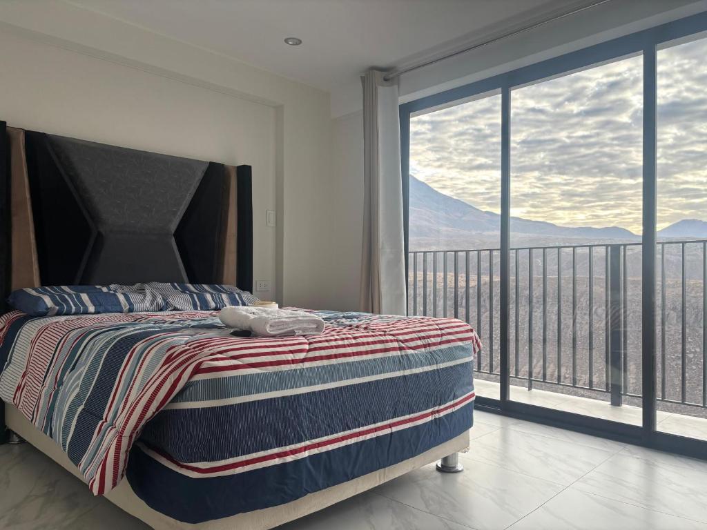 a bedroom with a bed and a balcony with mountains at Valle Alto in Cayma