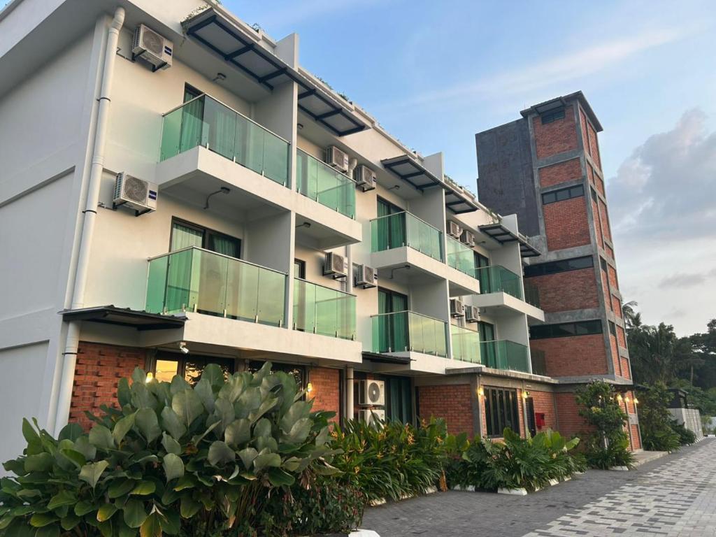 an apartment building with balconies and plants at Sena Hotel Langkawi in Kampung Padang Masirat