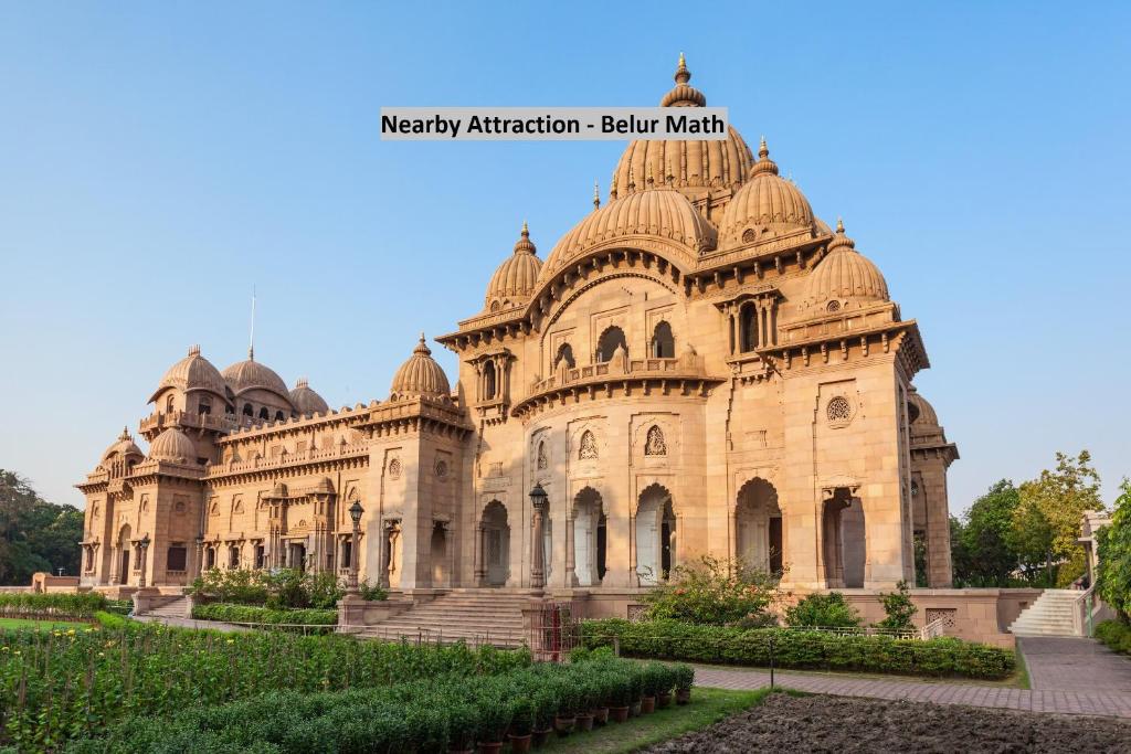 a large stone building with a garden in front at Super Collection O by OYO De Sivalika Boutique Near Dakshineswar Kali Temple in Kolkata
