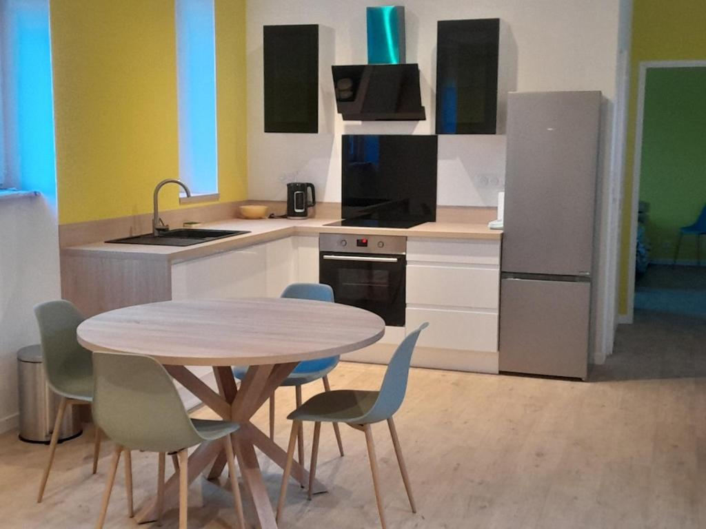 a kitchen with a table and chairs and a refrigerator at Peaceful Eden standing-magnificent view in Tulle