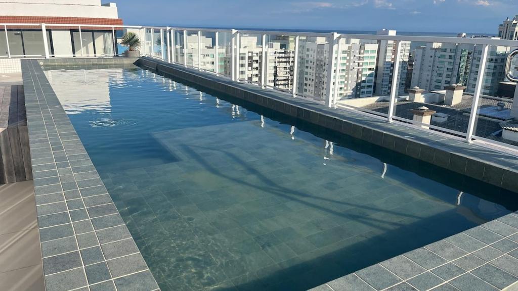 a large swimming pool on the roof of a building at Apartamento Novo in Capão da Canoa