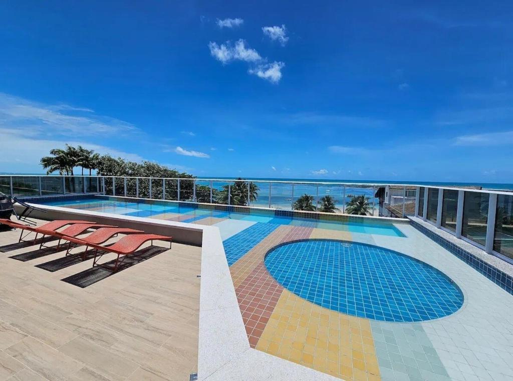 a swimming pool on the roof of a building at Estúdio a 1 min do mar - Mila rooftop in Tamandaré