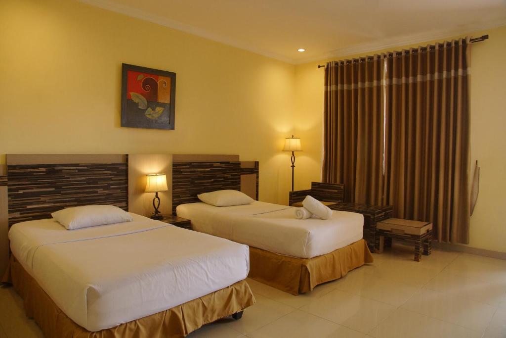 Giường trong phòng chung tại Ken Hotel by Tripletree