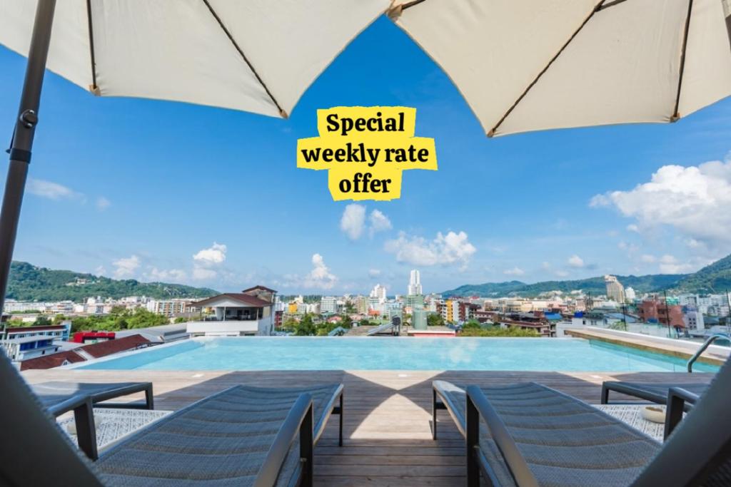 a swimming pool on the roof of a building at LullaBella Hotel Patong in Patong Beach