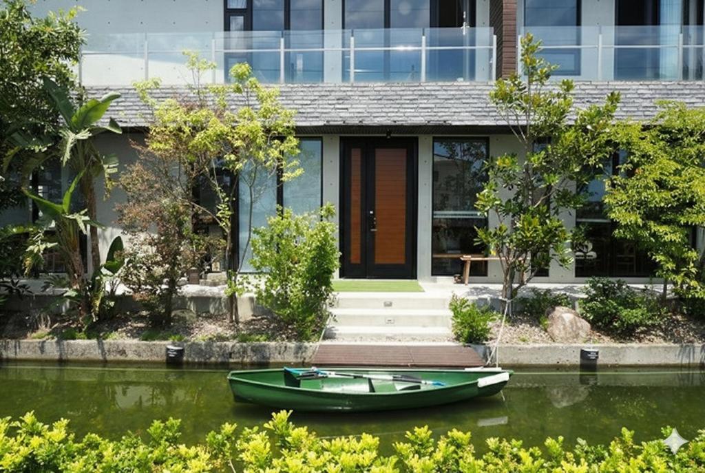 a house with a green boat in the water at Island Sunrise in Dongshan