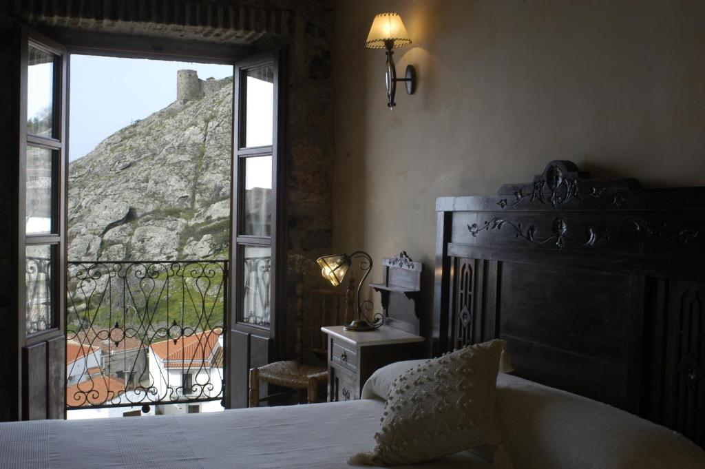 a bedroom with a bed and a view of a mountain at Casa Rural Canchalejo in Montánchez