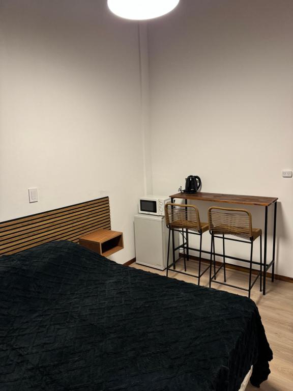 a bedroom with a bed and a table and a desk at Colonial suites in San Bernardo