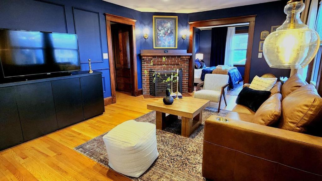 een woonkamer met een bank en een tv bij Prestigious Milton Designer Home in Milton