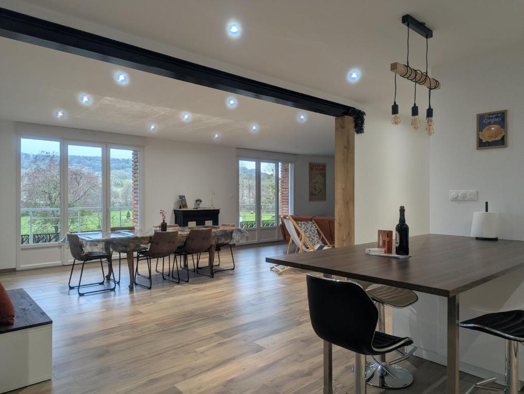 a dining room and living room with a table and chairs at Les champs dessus in Sarrey