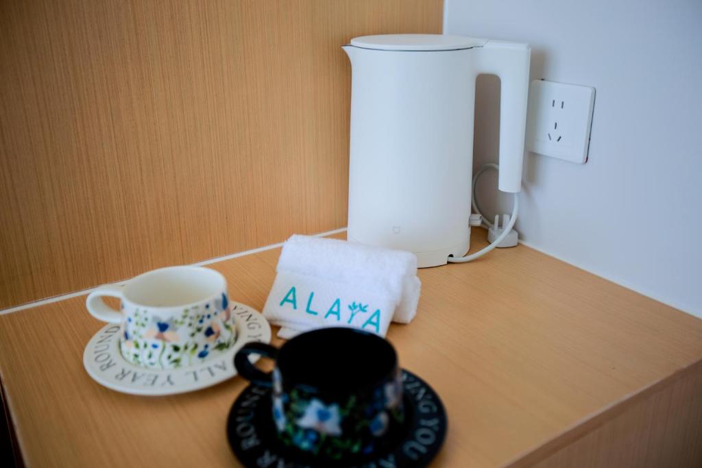 einen Tisch mit einer Kaffeetasse und einer Tasse drauf in der Unterkunft Alaya Beach Club 