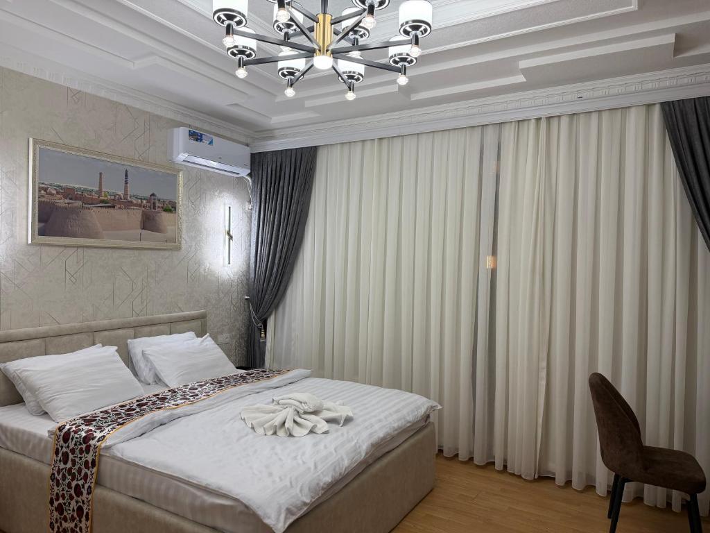 纳曼干Milliy Hotel - Namangan city的一间带床和吊灯的卧室