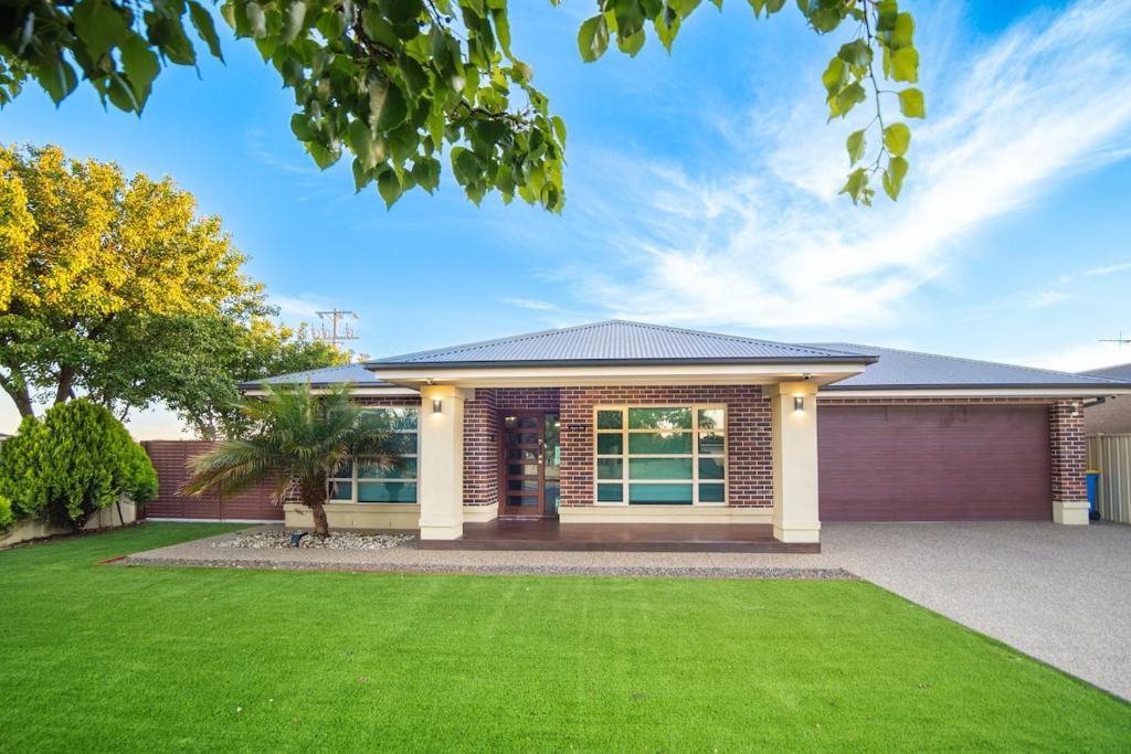 a house with a green lawn in front of it at Popular Grand Villa Shepparton in Shepparton