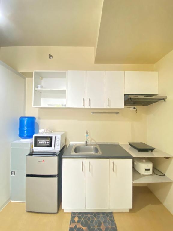 Centrio Tower Condo Units في كاغايان دي أورو: مطبخ صغير بخزائن بيضاء ومغسلة