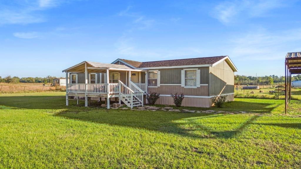 uma pequena casa com um alpendre e um quintal em The Country Haven em Huntsville