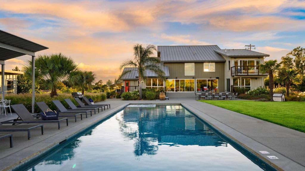 a house with a swimming pool with chairs and a house at Coplan Vineyards by AvantStay 10-Acre Estate w Pool Spa Bocce Designer Interiors in Sonoma