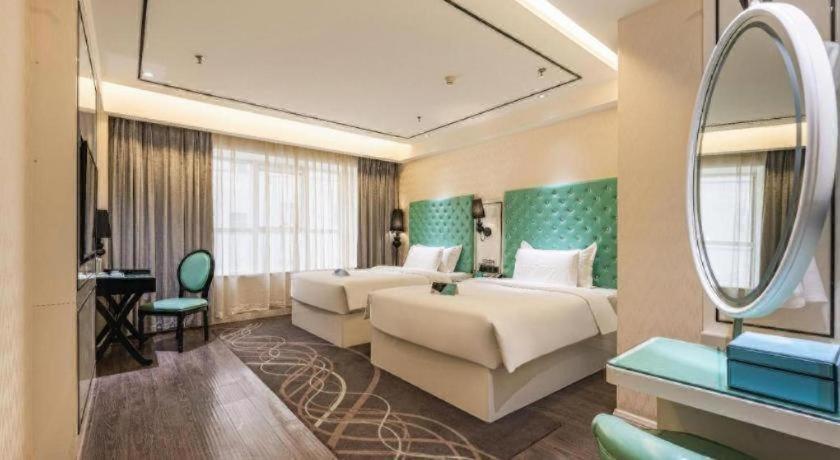 Xana Lite Korla Shihua Avenue Longquehe في كورلا: غرفة فندقية بسريرين ومرآة