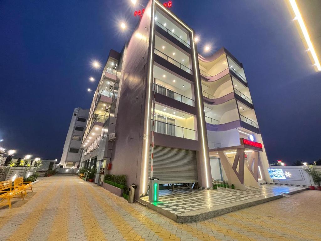 a large building at night with benches in front of it at Parth King Resort Tarapith A Unit of Prattay Infratech Private Limited in Tarapith