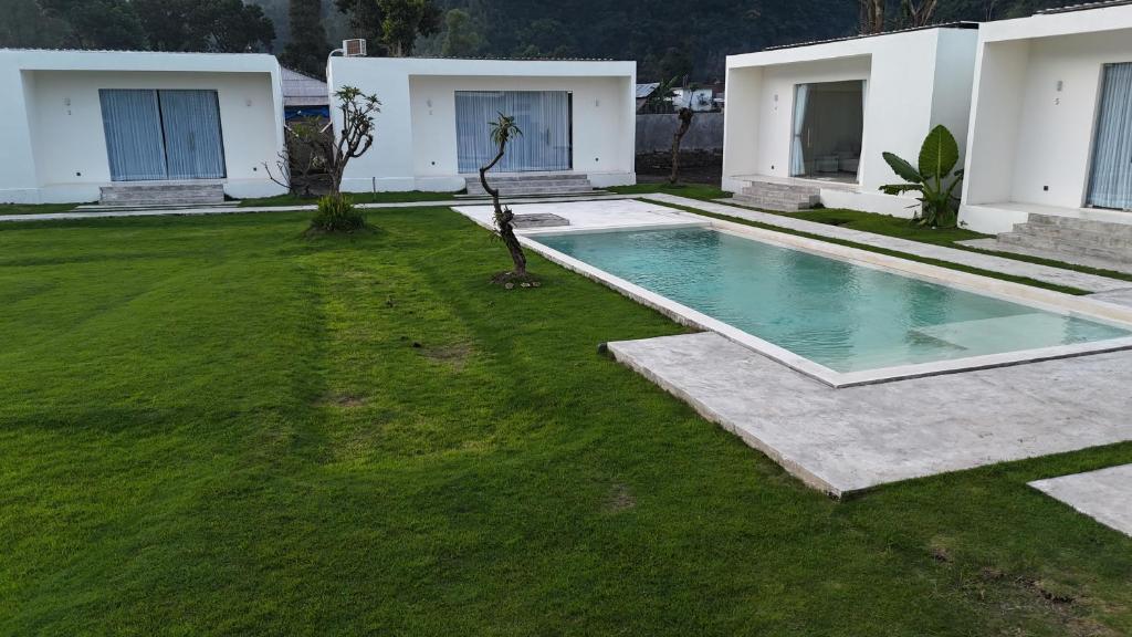 a backyard with a swimming pool and a grass yard at Volcano Bliss in Kintamani