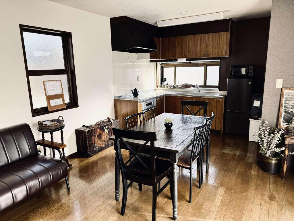 Maison Petit Lapin メゾンプチラパン في كارويزاوا: مطبخ وغرفة طعام مع طاولة وكراسي