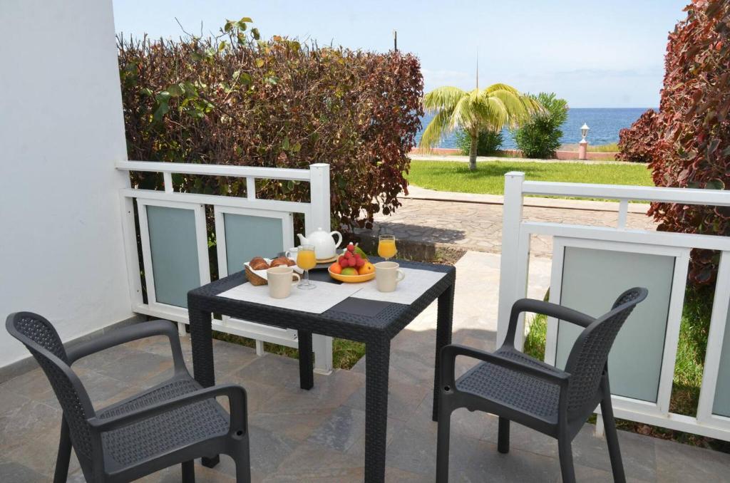 Apt. El Guirre Nº 8 - bajo في La Playa Calera: طاولة وكراسي على فناء مع المحيط