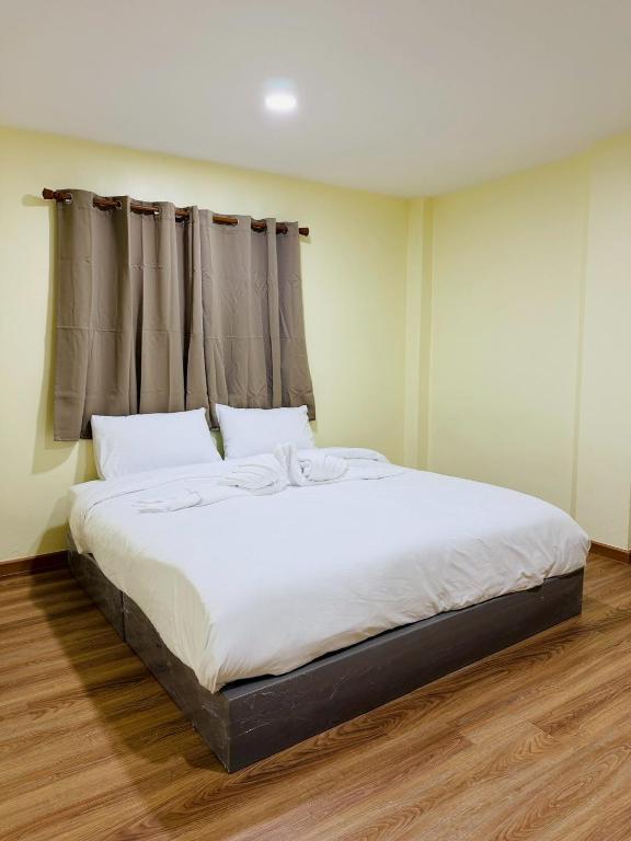 a bedroom with a large bed with white sheets at 79Hotel Rayong in Ban Hua Phrong