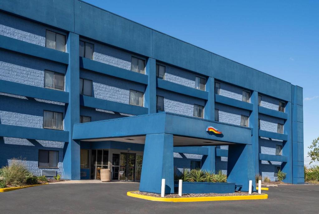 a blue building with a red car on top of it at Baymont by Wyndham Davenport in Davenport