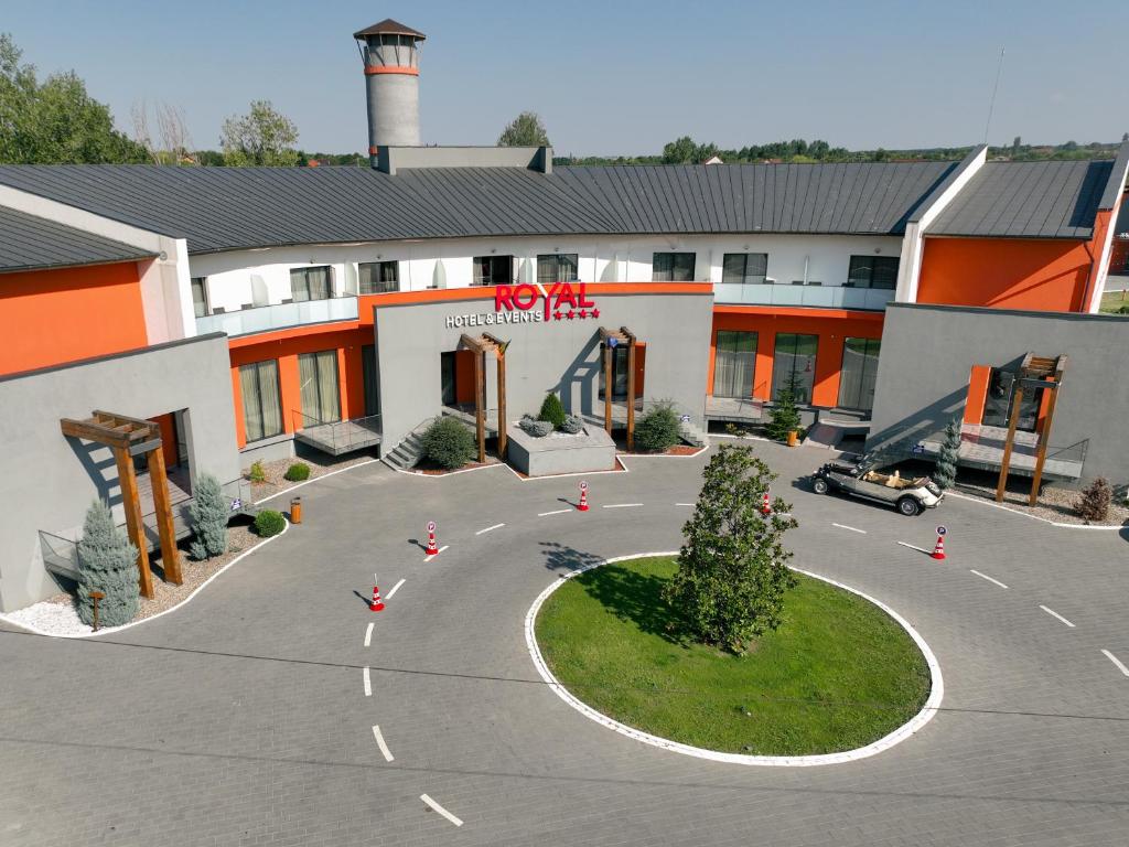 een gebouw met een parkeerplaats ervoor bij Royal Hotel & Events in Băileşti