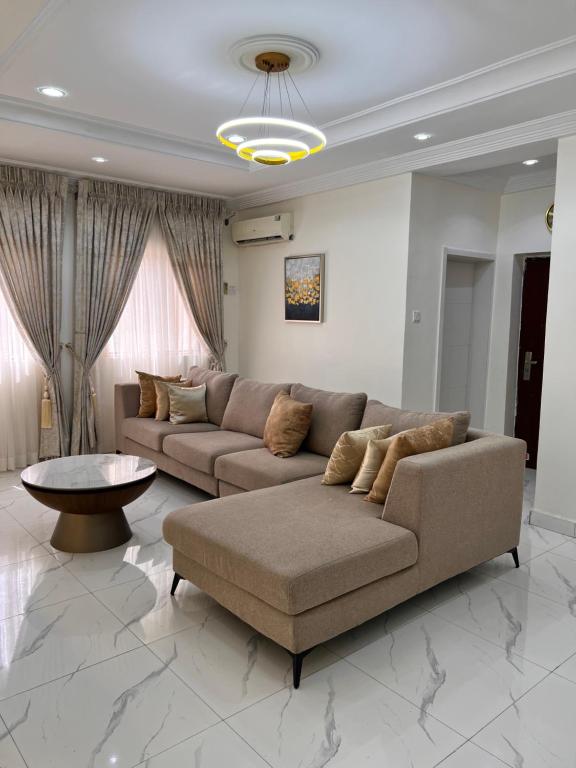 a living room with a couch and a table at Apo Luxe 3-Bedroom Apartment in Garki