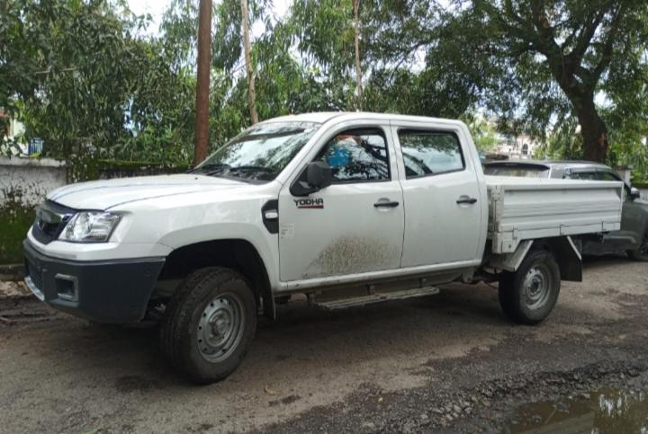 un pick-up blanc garé sur un chemin de terre dans l'établissement Caravan Camping Stay uttarakhand, à Mukteswar