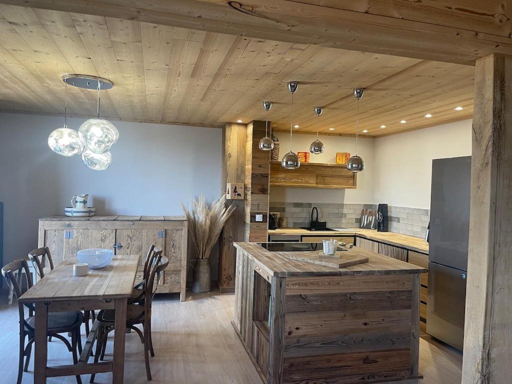 a kitchen with a wooden table and a dining room at Appartement avec vue panoramique in La Celle-sous-Gouzon