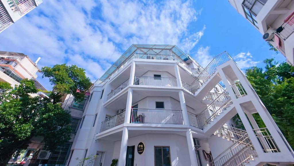 een wit gebouw met een balkon bij Tianya No.7 Homestay in Sanya