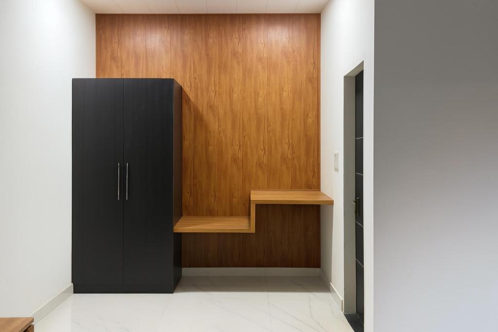 FīrozābādThe RB's Farm的一个带黑色柜子和木门的衣柜