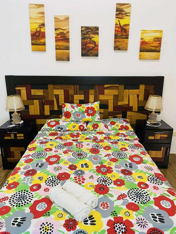 a bedroom with a bed with a colorful comforter at Couple room A in Final Destination Resort in Bolinao
