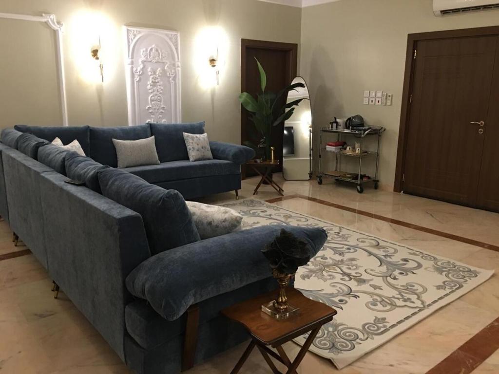 a living room with a blue couch and a table at Big studio apartment in Makkah