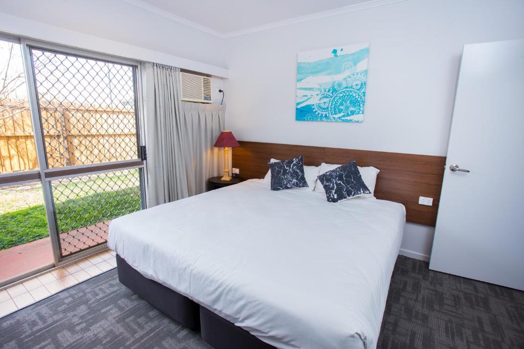 a bedroom with a large bed and a large window at Wilsonton Hotel Toowoomba in Toowoomba