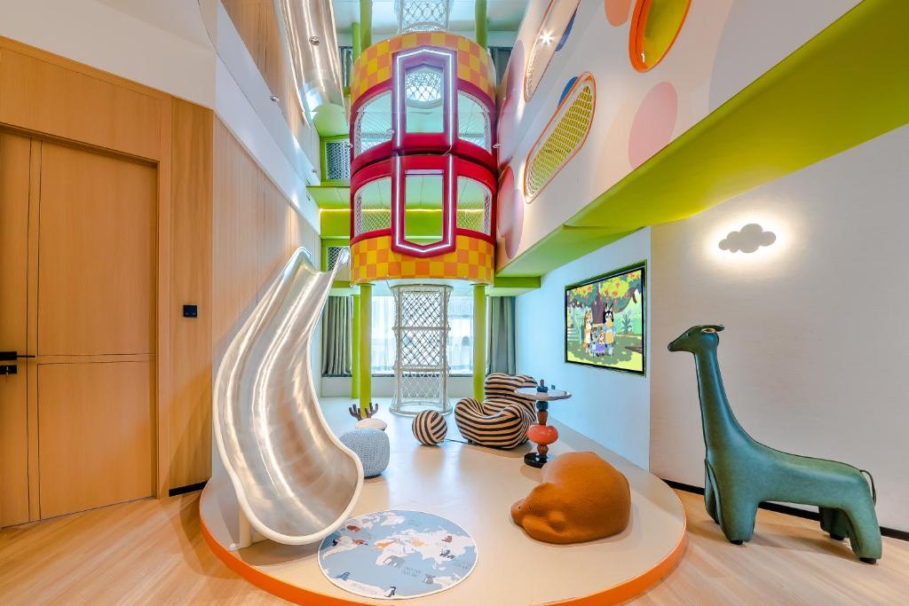 ein Kinderspielzimmer mit Rutsche und Spielplatz in der Unterkunft Miomi Family Hotel in Qingdao