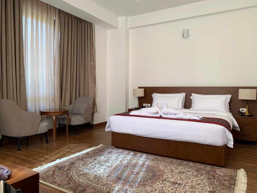a hotel room with a bed and a table and chairs at Hotel pema raga in Thimphu