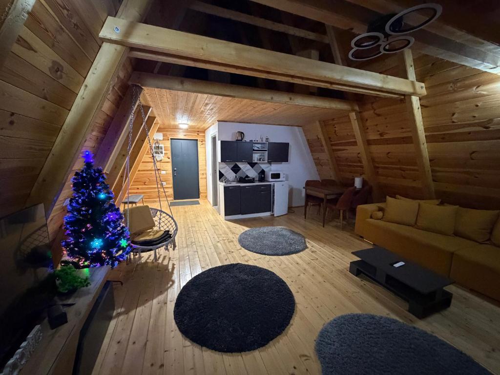 una sala de estar con un árbol de Navidad en una cabaña en Colț de RAI A-Frame, en Drumu Carului