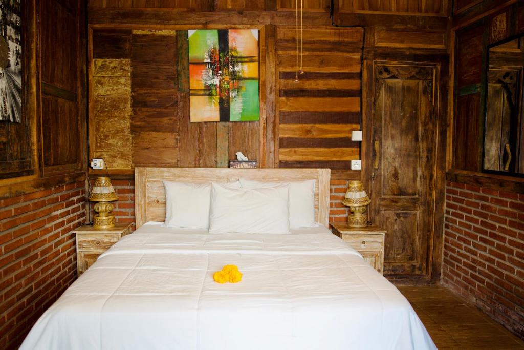 a bedroom with a white bed with a yellow flower on it at Alain rooms AMED in Amed