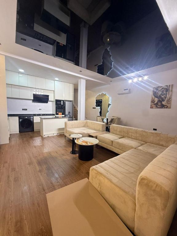 a large living room with a couch and a kitchen at Estelle Service Apartments Limited in Ikate