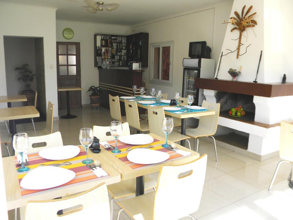 jadalnia ze stołem, krzesłami i kominkiem w obiekcie Hotel H1 Antsirabe w mieście Antsirabe