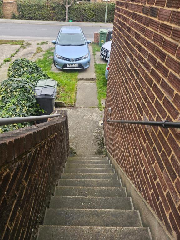 een auto geparkeerd op een parkeerplaats naast een bakstenen muur bij 14 london road in Stonewood