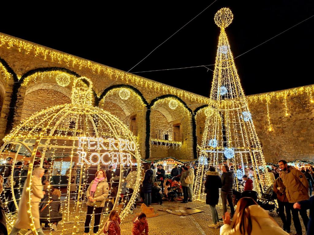 ein Weihnachtsmarkt mit einem Weihnachtsbaum und Lichtern in der Unterkunft Casas del Castillo Peñíscola-Intramuros Suites in Peñíscola