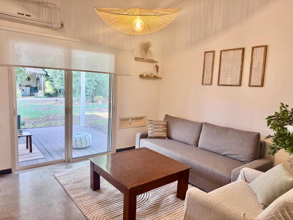 una sala de estar con un sofá y una mesa en הבית של דובי, en Kfar Blum
