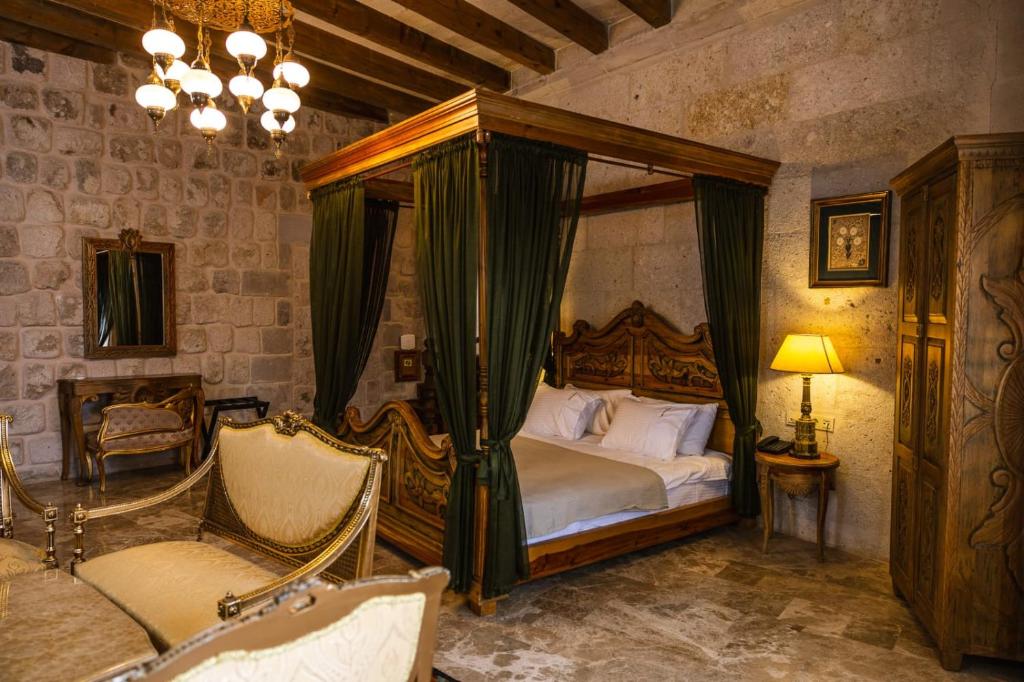 Ages in Cappadocia Premium في أوشيسار: غرفة نوم مع سرير بمظلة وكرسيين