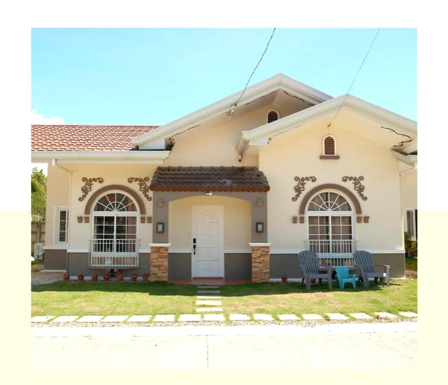 Villa Izabella in Panglao Island في داويس: منزل أبيض مع كرسيين في الفناء