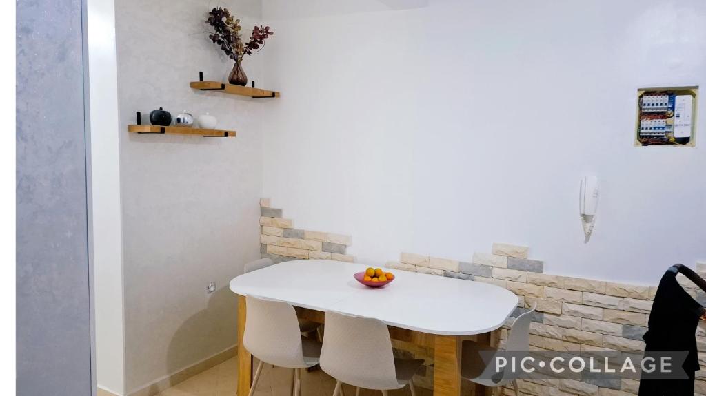 a white table with two chairs and an orange on it at Le cocon drargua in Agadir