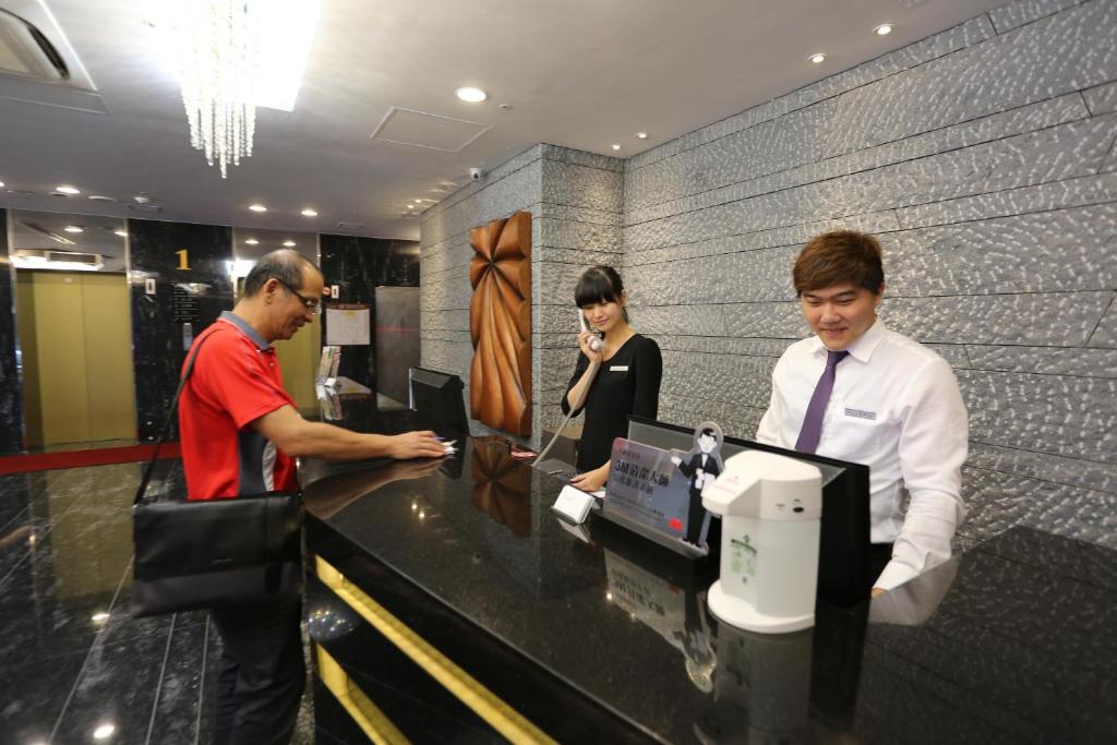 a group of people standing at a cash register at Chiayi Look Hotel in Chiayi City