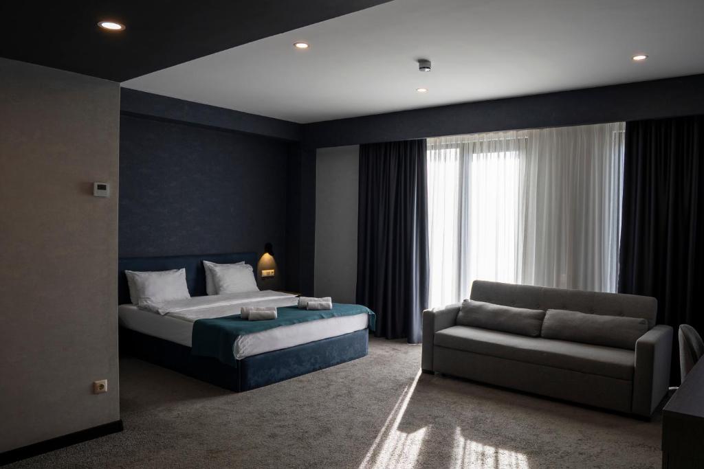 a bedroom with a bed and a couch at The West Inn-Georgia Hotel in Kutaisi