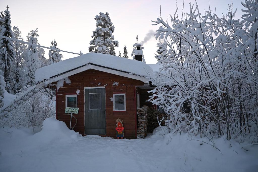 a small cabin with snow on top of it at Holy Motors camp in Kvikkjokks Kapell
